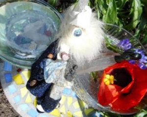 giant red poppy in garden with penstemon and large lemuria quartz